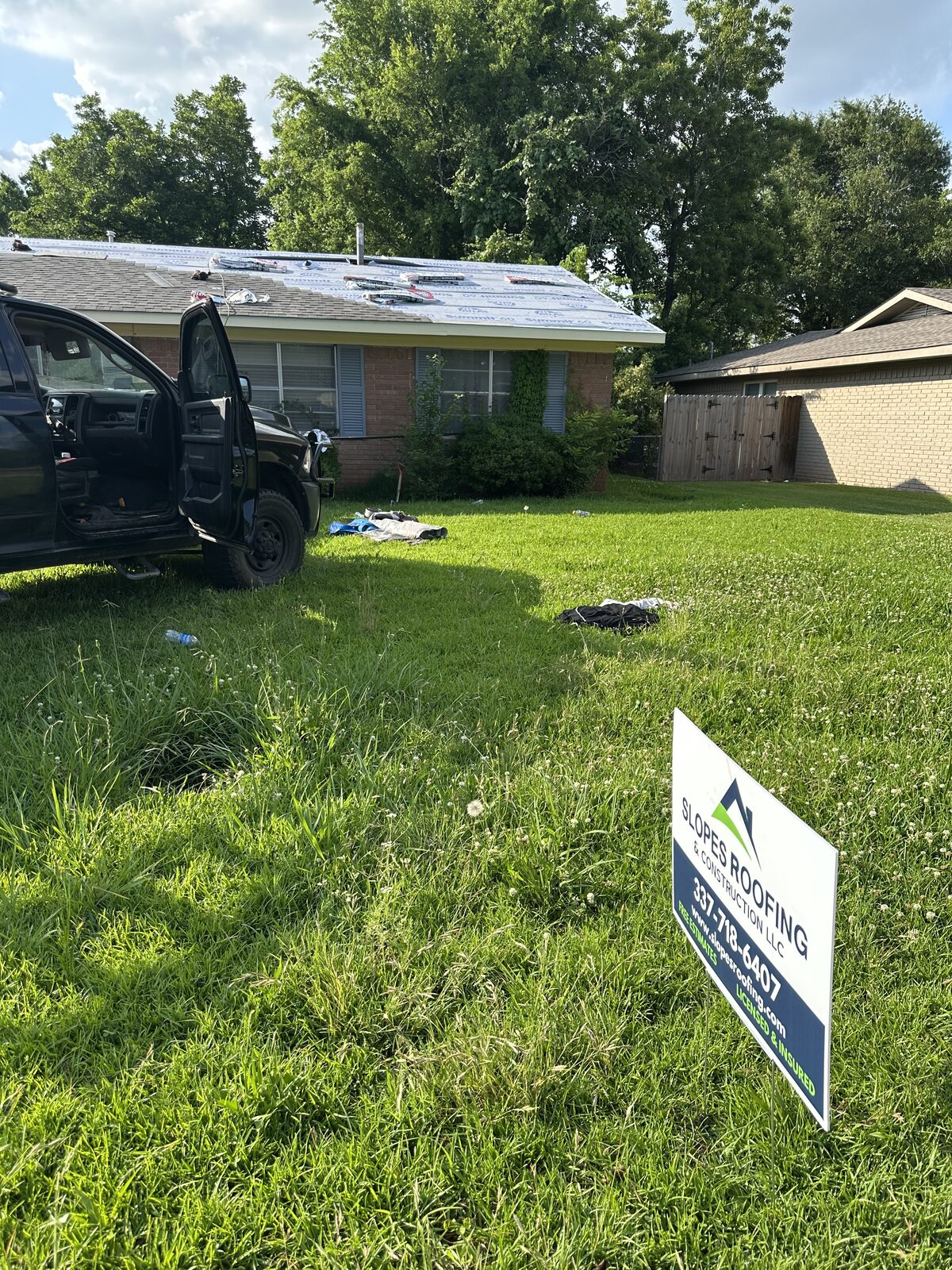 Slopes Roofing yard sign in front of a home during a roof replacement